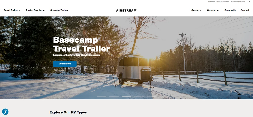 Airstream website homepage featuring Basecamp travel trailer in a snowy outdoor landscape.